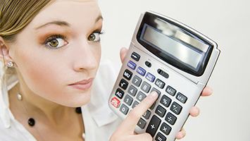 Femme avec une calculatrice à la main pour calculer un salaire