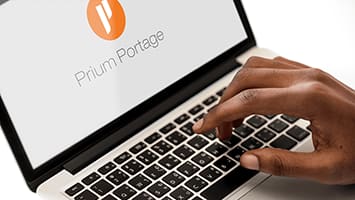 Main tapant sur un ordinateur portable avec le logo Prium Portage