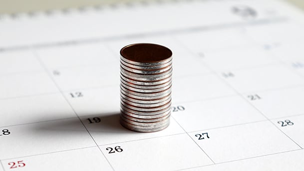 Une pile de pièces de monnaie identique sur un calendrier